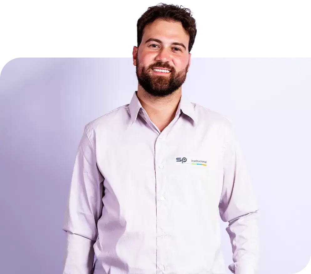 SP< Uniformes - Homem vestindo camisa social manga longa com logo de empresa bordada na lateral superior da peça.