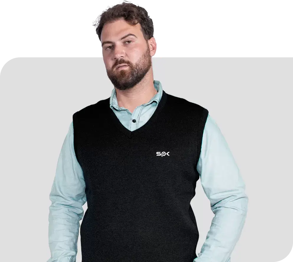 SP< Uniformes - Homem vestindo colete de lã sobre camisa social. O colete possui logo de empresa bordada na lateral superior da peça.