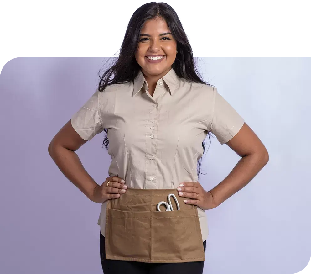 SP< Uniformes - Mulher vestindo camisa social manga curta e avental funcional, com dois bolsos.